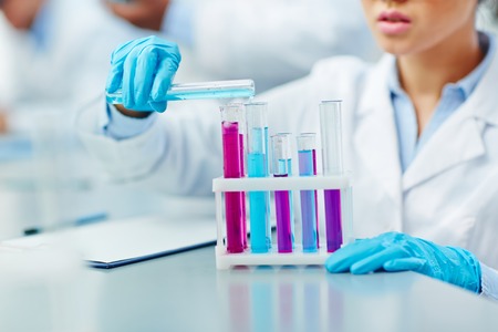Young woman working with chemical substances in scientific laboratory