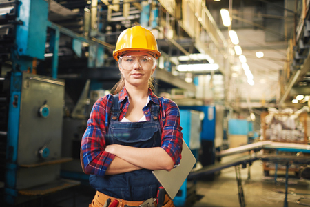 Portrait of young woman in protective glasses in the factoryの写真素材