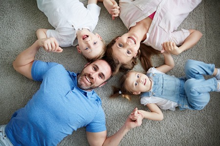 Portrait of happy family lying on floorの写真素材