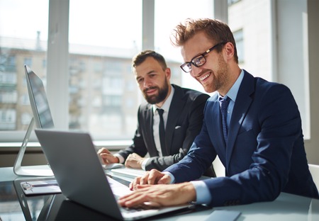 Two business partners working with laptop togetherの写真素材