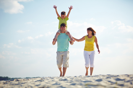 Happy family enjoying the time on the beach togetherの写真素材