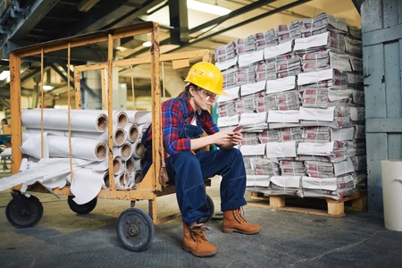 Female worker sitting and texting on her cellphone