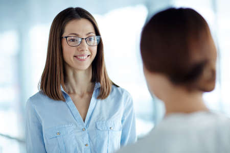 Young businesswoman listening to her colleagueの写真素材
