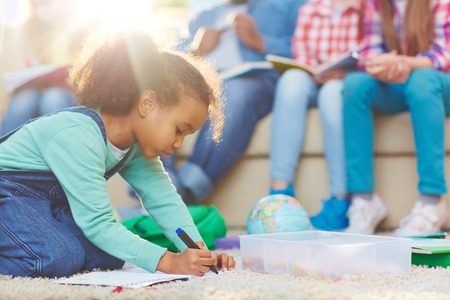 Little girl drawing with highlighter