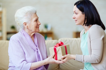 Young woman giving present to her motherの写真素材