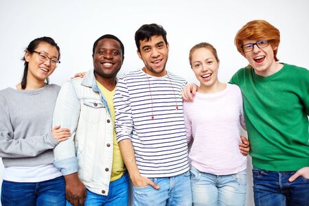 Happy students in casual-wear looking at camera
