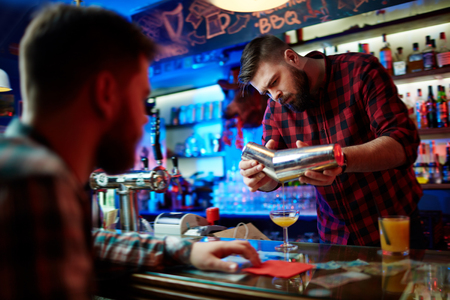 Young barman making cocktail for clientの写真素材