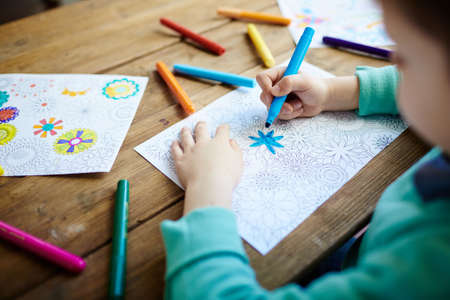 Little boy coloring creative pictures with highlightersの写真素材