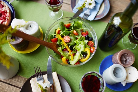 Bowl with vegetarian salad on dinner tableの写真素材
