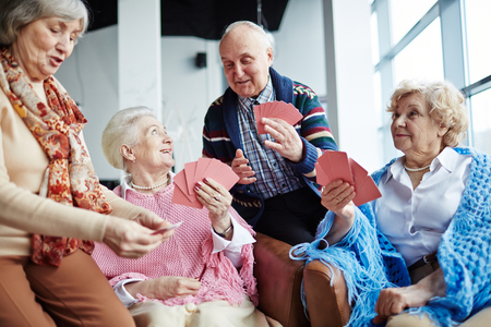 Group of friendly seniors playing cards at leisureの写真素材