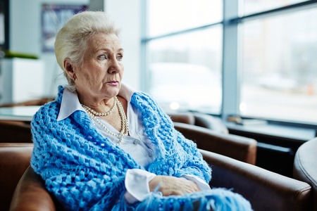 Senior female sitting in arm-chairの写真素材