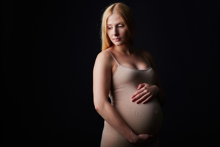 Pretty pregnant woman touching her belly