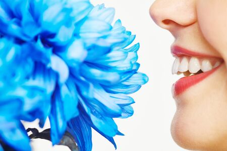 Close-up of female face smelling a flowerの写真素材