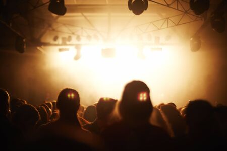 Crowd of fans at concert in night clubの写真素材