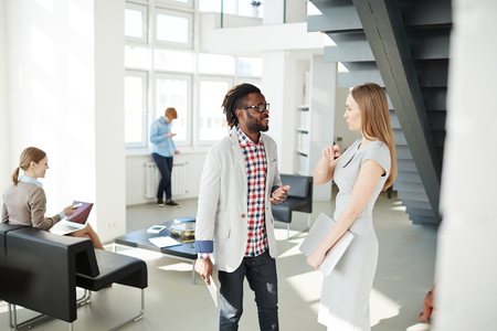 Multi-ethnic colleagues communicating in working environment in officeの写真素材