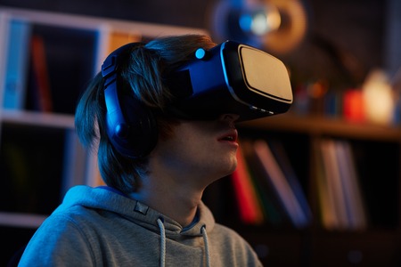 Contemporary guy in virtual reality headset watching video