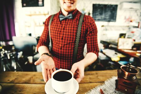Male barista serving hot coffeeの写真素材