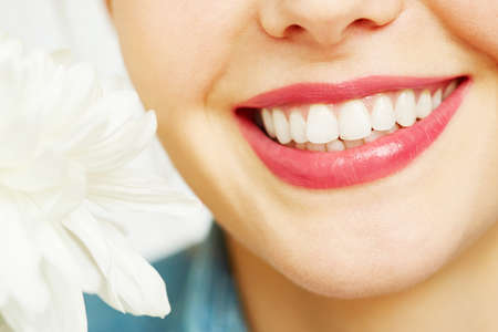 Close-up of female teeth and a flowerの写真素材