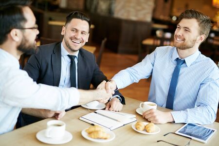 Employees handshaking in cafe at break