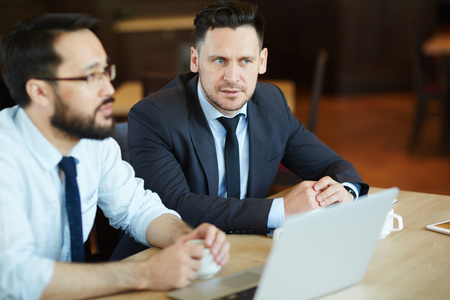 Colleagues sitting in cafe by cup of coffeeの写真素材
