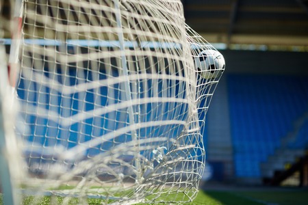 Soccer ball flying into the netの写真素材