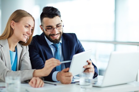 Colleagues discussing data on touchpadの写真素材