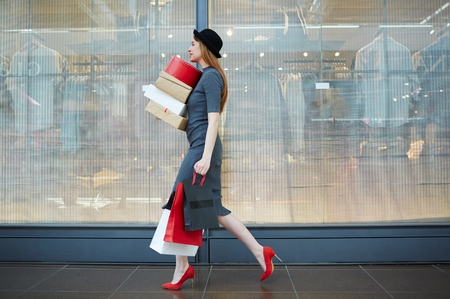 Elegant woman walking in the mall with bags and boxesの写真素材