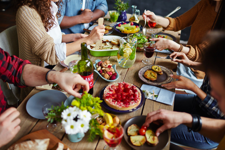 Group of people sitting at festive table and eatingの写真素材