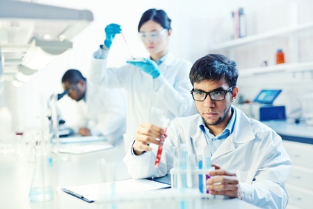 Lab worker looking at liquid in tubeの写真素材