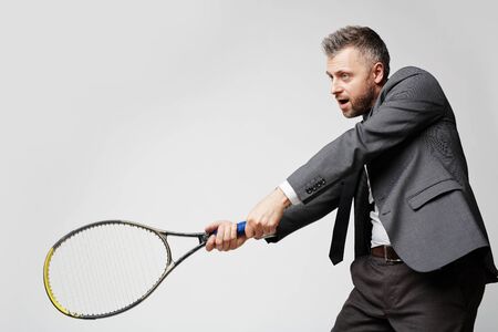 Confident employer in smart suit artfully playing tennis with his business rival, the idea of image is professionalism of modern entrepreneurの写真素材