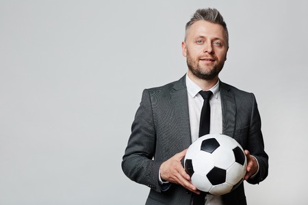 Elegant businessman or soccer coach with ballの写真素材