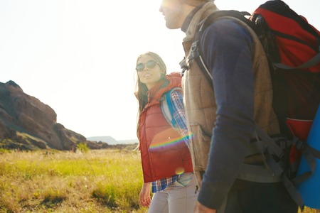 Couple of hikers with backpacks having trip