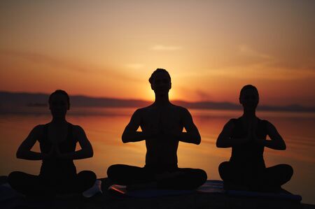 Relaxing people practicing yoga at leisureの写真素材