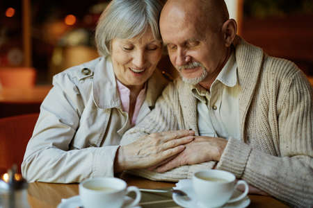 Affectionate senior couple relaxing in cafeの写真素材