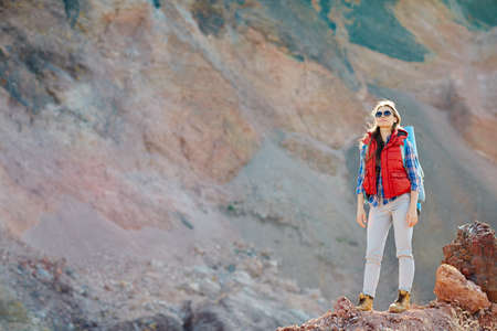 Modern traveler standing on cliff against mountain backgroundの写真素材