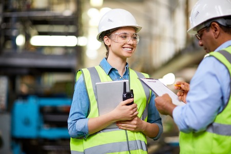 Female engineer talking to her co-workekr at plantの写真素材