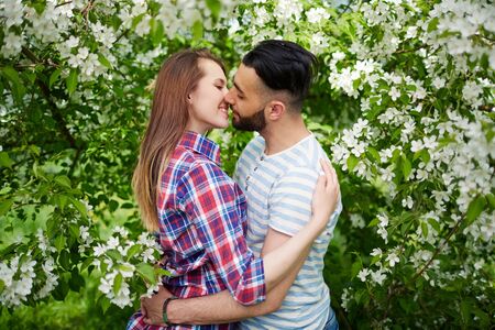 Happy amorous couple embracing in blooming gardenの写真素材