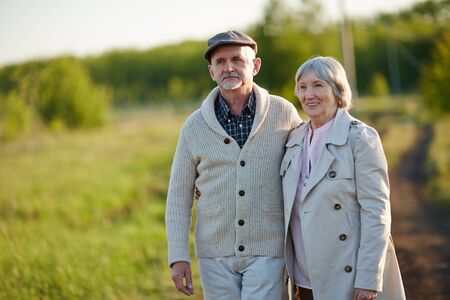 Two pensioners taking walk in rural environment