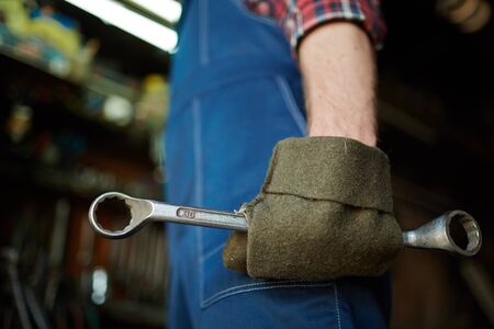 Gloved hand of mechanic with box wrenchの写真素材