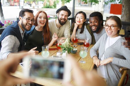 Carefree friends posing for camera in cafe