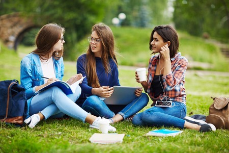 Modern teens talking during rest in parkの写真素材