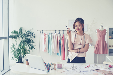 Portrait of young dressmaker standing near the workplaceの写真素材