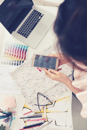 Woman photographing fabric on her phoneの写真素材