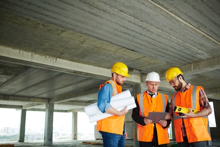 Team of inspectors discussing data on construction site
