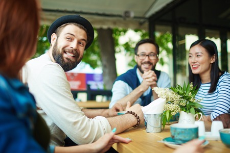 Happy man looking at girl during talk in cafeの写真素材