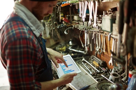 Mechanic analyzing sell data at workの写真素材