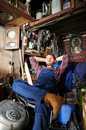 Young repairman relaxing in his workshopの写真素材