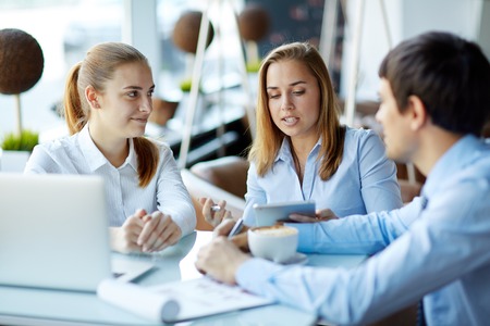 Group of employees using modern gadgets in workの写真素材