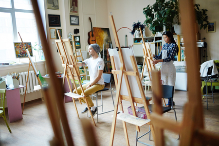 Young artists busy with painting at art studioの写真素材