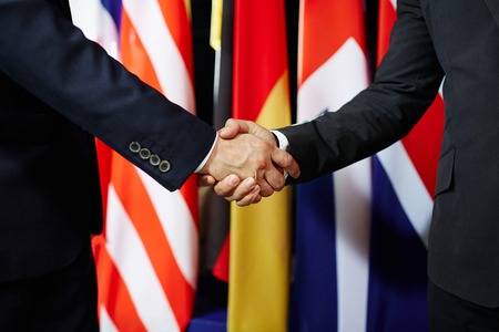Close-up of two politicians in suits shaking handsの写真素材